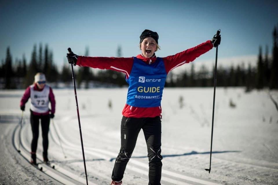 Ledsager smiler mot kamera